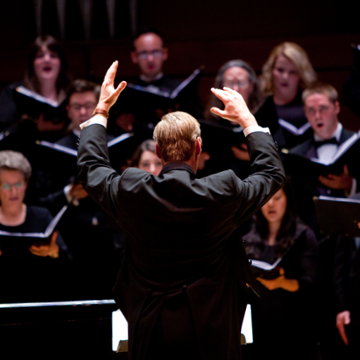 332 Photo of group of choral singers with conductor in front.